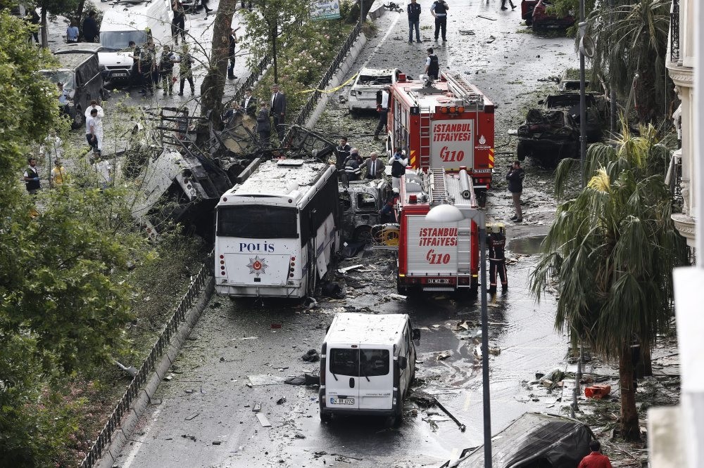 Police officers inspecting the area after a bomb attack yesterday on a police bus, killing 12 and wounding 42 in Istanbul's Vezneciler district.