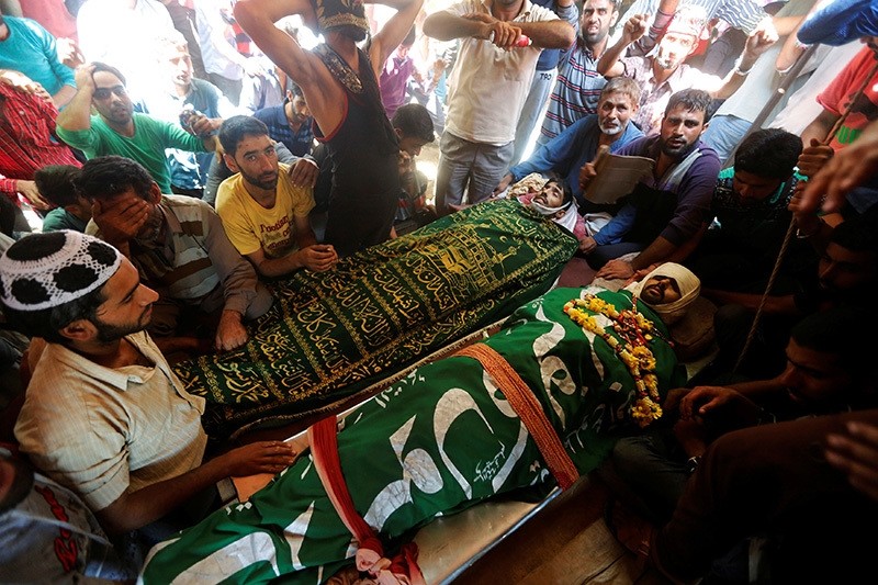 Kashmiri villagers sit next to the bodies of civilians, who according to local media were killed during clashes between police and protesters, during their funerals in Beerwah, north of Srinagar, August 16, 2016. (Reuters Photo)