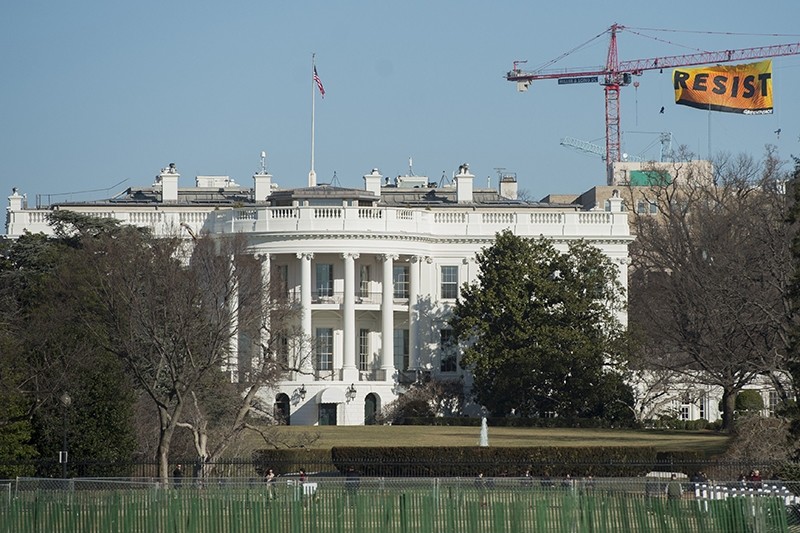 Greenpeace protesters unfold a banner reading ,Resist, from atop a construction crane behind the White House January 25, 2017 in Washington, DC. (AFP Photo)