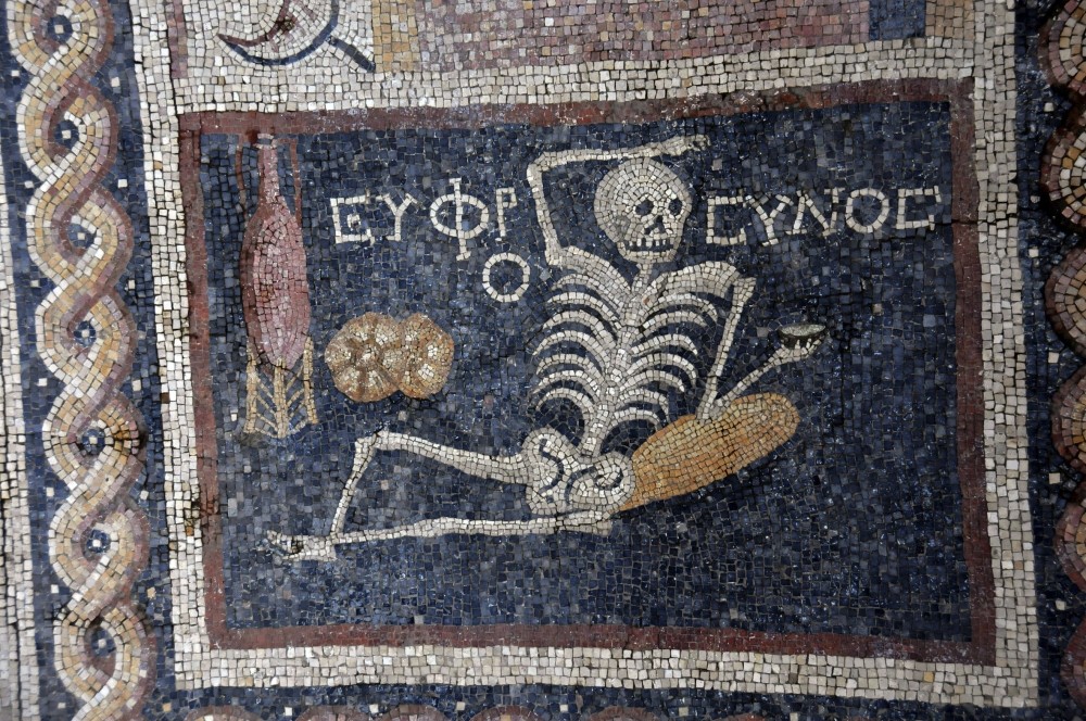A 2,400 year old Roman mosaic depicts a skeleton lying down with a jorum in his hand, a wine pitcher and bread on the side with an inscription translated as u201cbe cheerful, enjoy your life.u201d