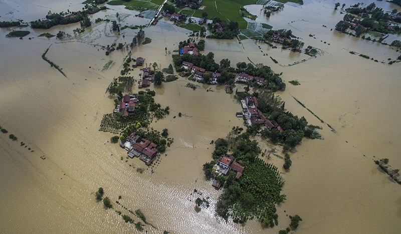 This Wednesday photo released by Xinhua News Agency, shows village houses and field partially submerged by flood waters in Gaoyang Town, Shayang County, central China's Hubei Province. (Xinhua via AP Photo)