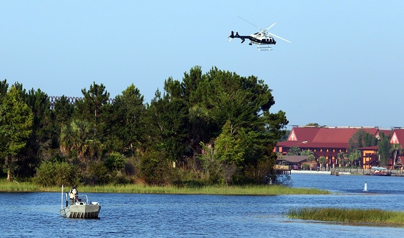 Florida Fish and Wildlife and an Orange County Sheriffs helicopter search for a young boy early Wednesday, June 15, 2016 (AP Photo)