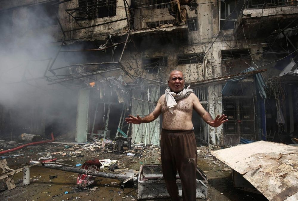 An Iraqi man shouts after a bomb destroyed his home in Baghdad.