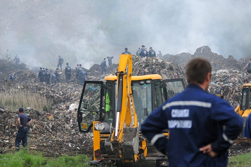 Rescue workers investigate a trash dump near Grybovychi village near Lviv, Ukraine, May 30, 2016.