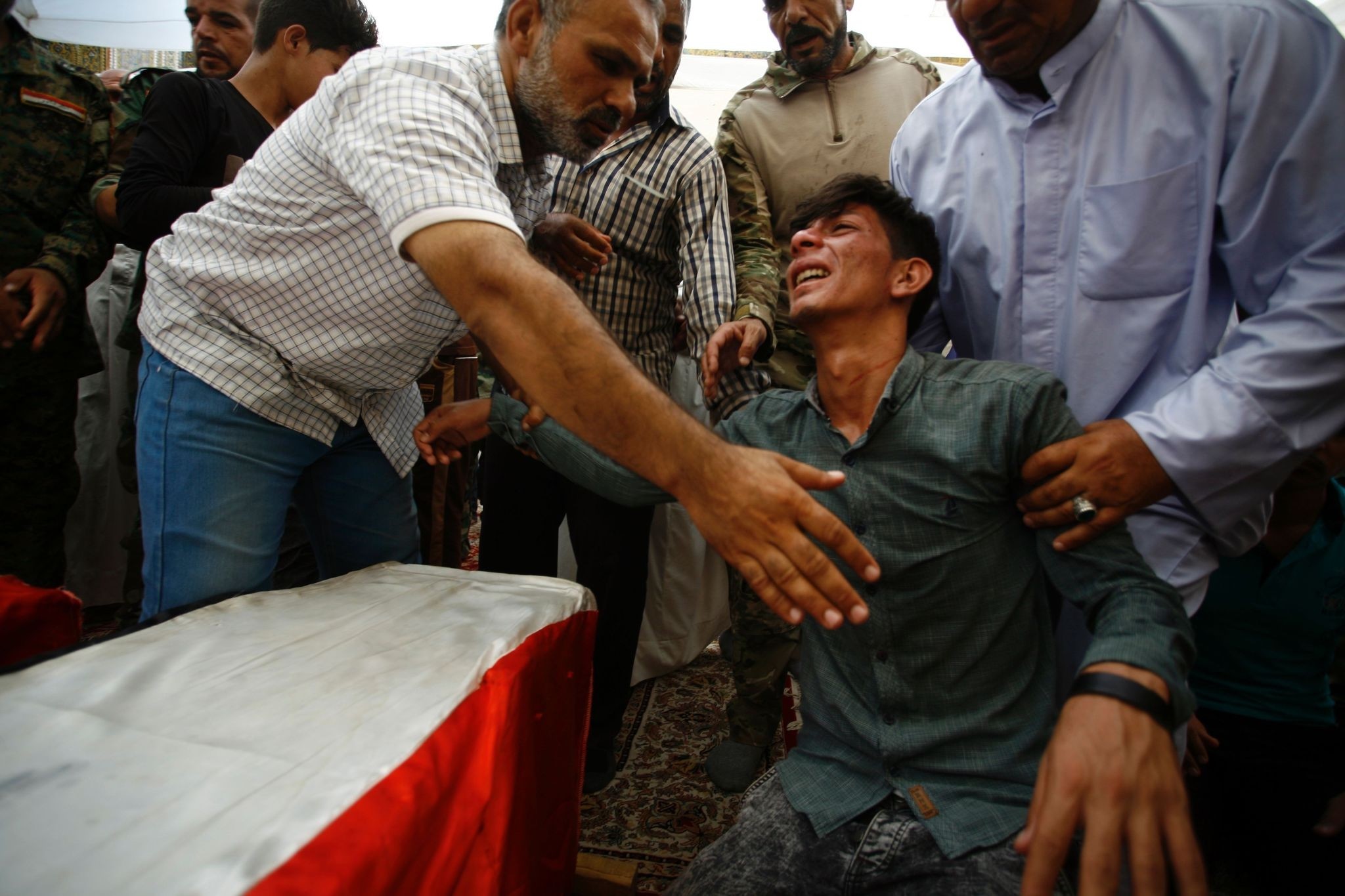 Iraqis mourn over the coffins of Shiite students who were killed in the Khalidiyah area of Iraq's Anbar province fighting alongside pro-gov't forces in the battle against Daesh. (AFP Photo)