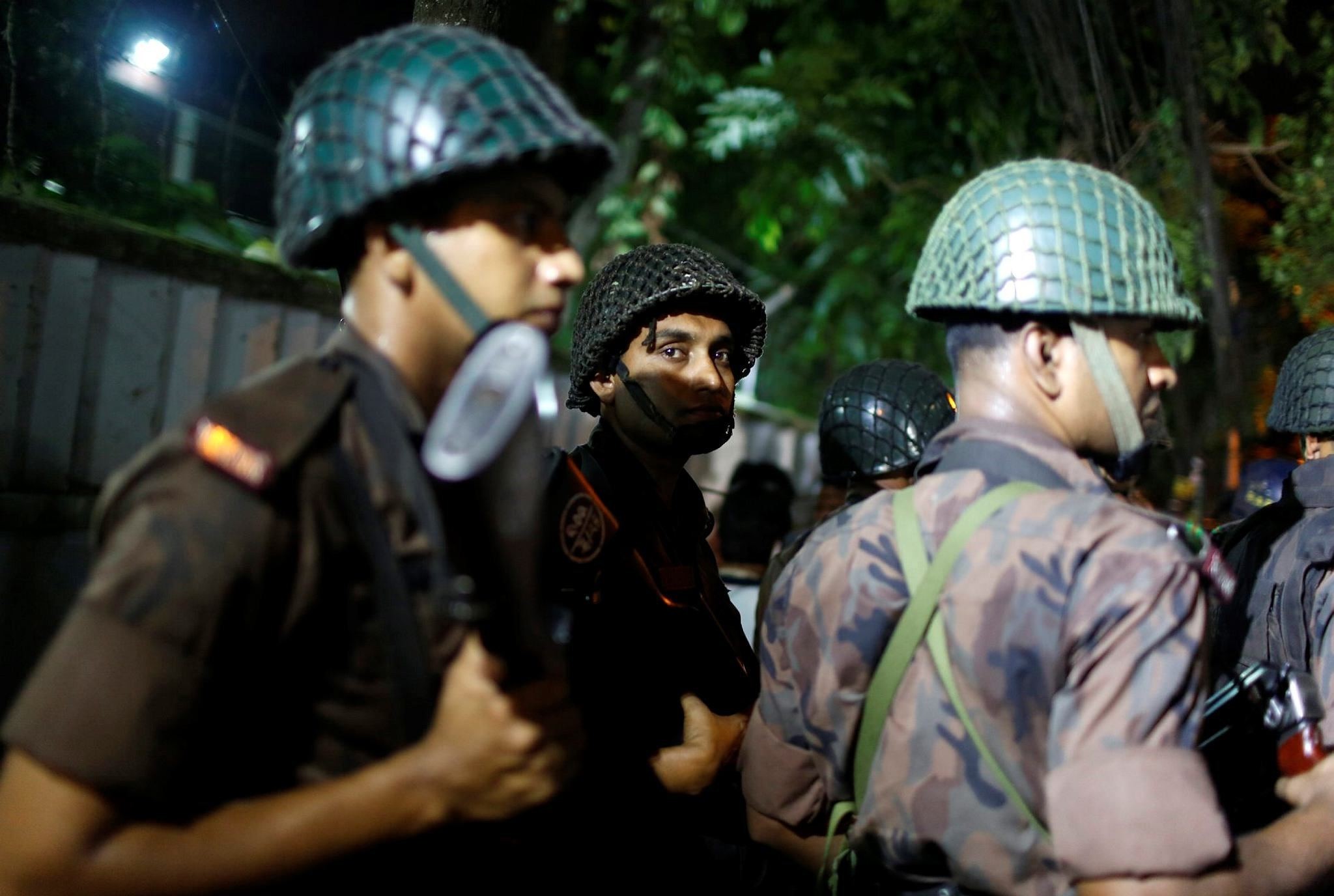 Bangladeshi security personnel stand guard near a restaurant that has reportedly been attacked by unidentified gunmen in Dhaka, Bangladesh, Friday, July 1, 2016. (AP Photo)