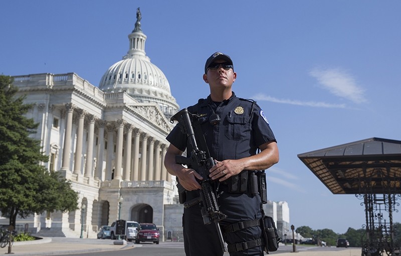 A US Capitol Police officer holds a firearm outside the US Capitol Building while it is on lockdown, in Washington, DC, USA, 08 July 2016 (EPA Photo)