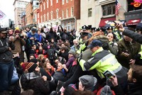 Demonstrators sit down at 10th Street near Pennsylvania Avenue to prevent spectators from reaching one of the entrances to the parade route to protest Trump. (EPA Photo)