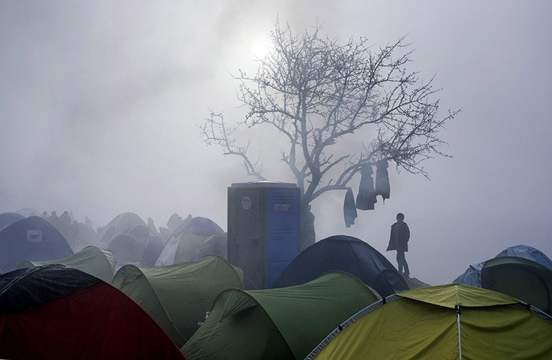 A boy stands among tents during a foggy morning at a makeshift camp near the Greek village of Idomeni on March 8, 2016. (AFP Photo)