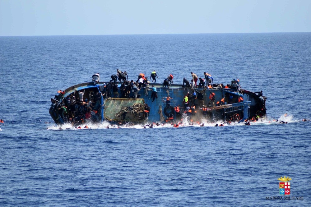 People jump out of a boat right before it overturns off the Libyan coast, May 25.