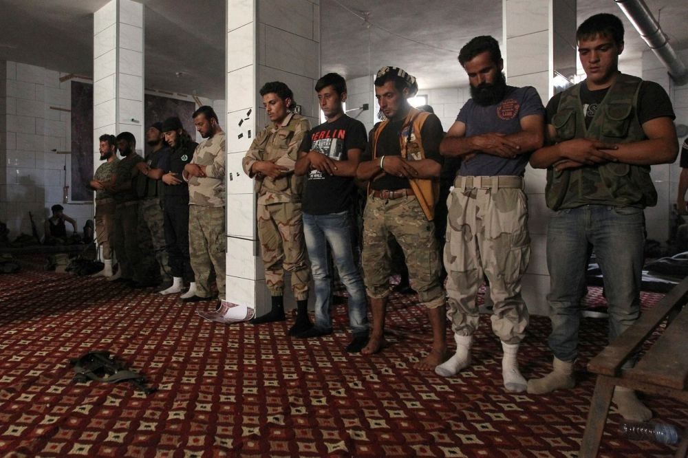 Opposition fighters pray in a safe house in Aleppo during the assault.