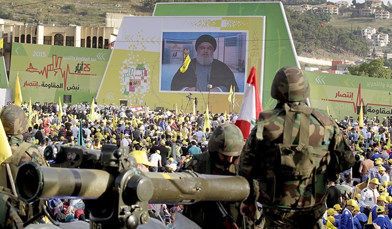 Hezbollah supporters listening to a speech by leader Hassan Nasrallah (on screen), as he delivers a speech on May 25, 2015 to celebrate the 15th anniversary of the Israeli withdrawal from south Lebanon. (EPA Photo)