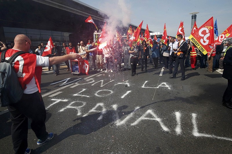 Striking employees hold French CGT labour union flags during a demonstration against the labour reforms law at the Charles de Gaulle Intu2019l Airport in Roissy, near Paris, France, June 7, 2016. The slogan reads ,No to the labour law,. (Reuters Photo)
