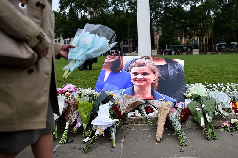 Floral tributes sit by a picture of slain Labour MP Jo Cox in Parliament Square, central London on June 17, 2016 (AFP Photo)