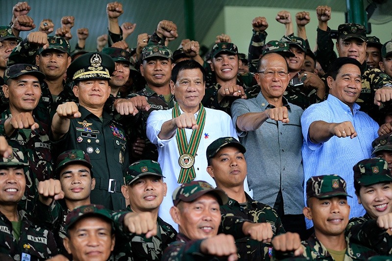 Philippines President Rodrigo Duterte (C) clenches fist with members of the Philippine Army during his visit at the army headquarters in Taguig city, metro Manila, Philippines October 4, 2016. (Reuters Photo)