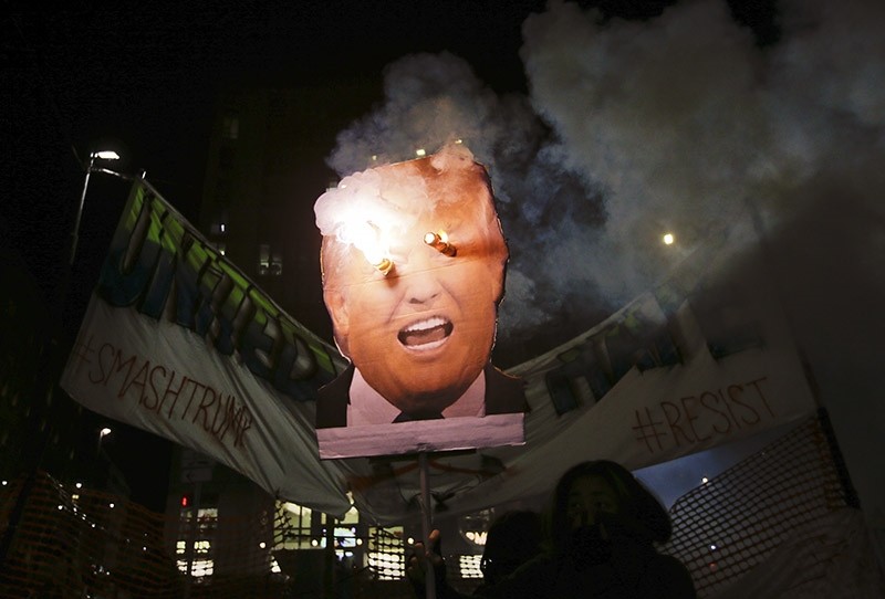 Protesters burn a picture of U.S. President Donal Trump. Jan. 20, 2017. (AP File Photo)