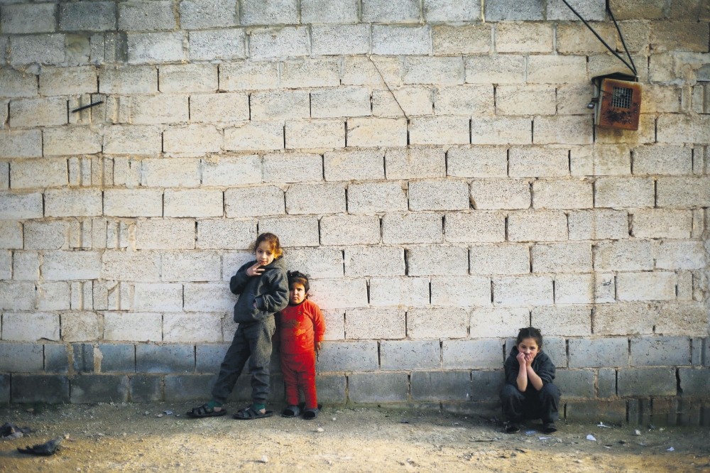 Syrian girls, who fled the village of Deir Hafer with their family, watching their brothers play in the town of Safira, south of Aleppo, Jan. 18.