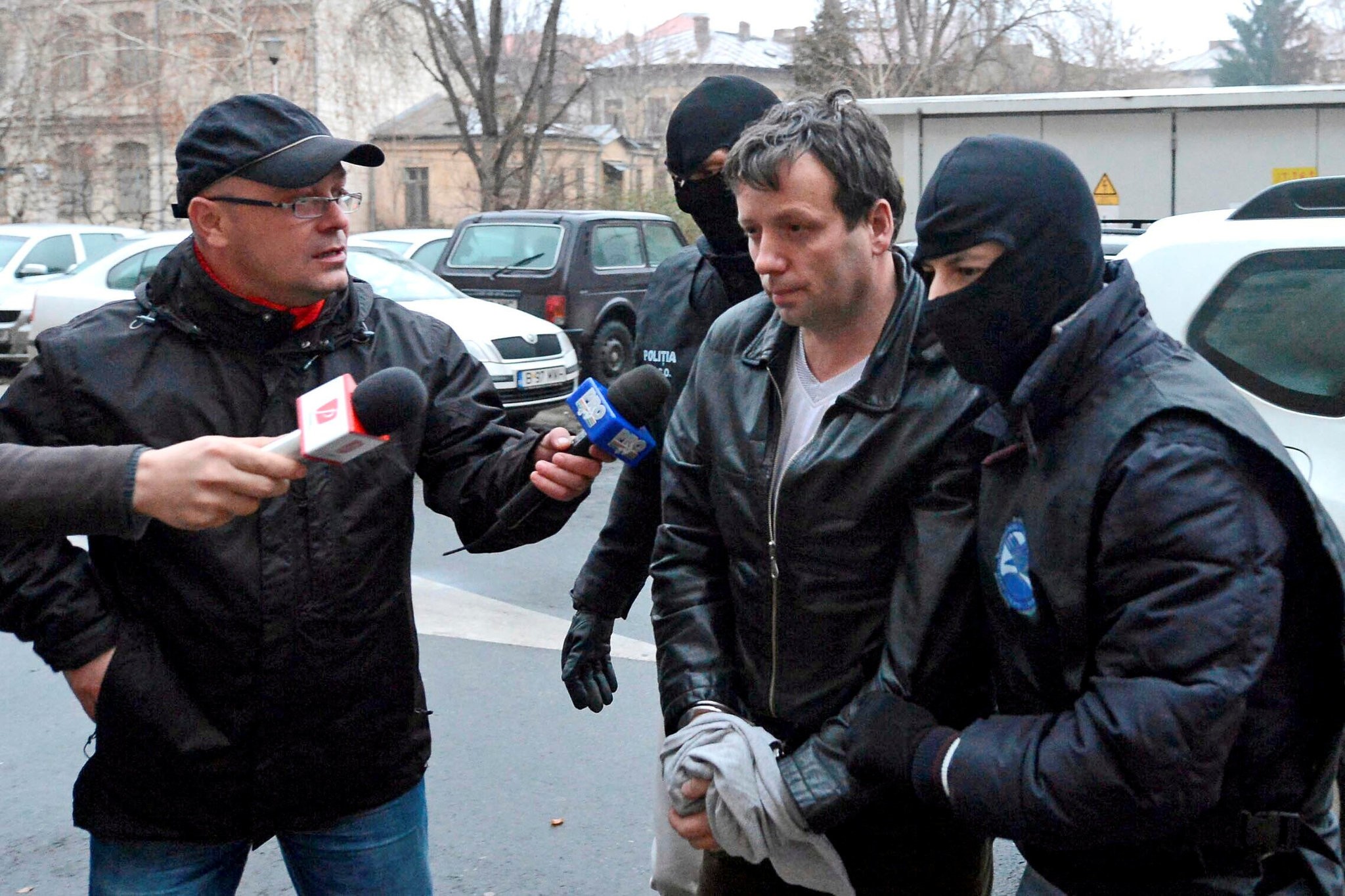 Marcel Lazar Lehel is escorted by masked policemen in Bucharest, after being arrested in Arad, 550 km (337 miles) west of Bucharest January 22, 2014. .(REUTERS Photo)