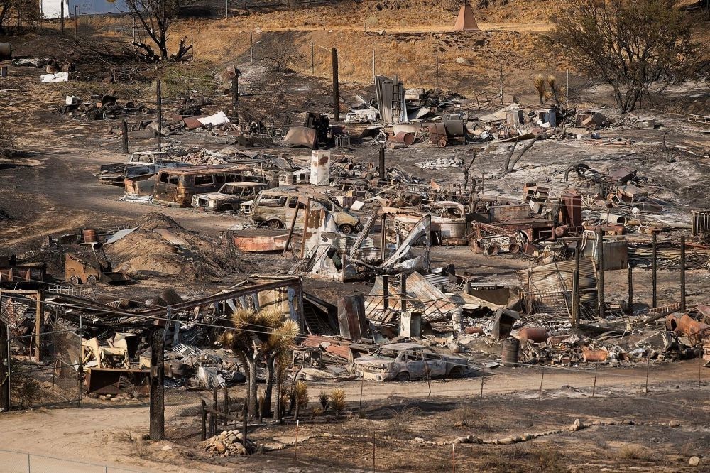 Scorched cars and trailers burned by the Blue Cut fire line a residential street in California.