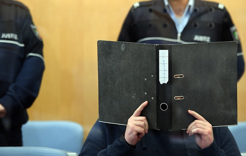 Alleged Daish terrorist Kerim Marc B. holds an empty binder in front of his face in Duesseldorf, Germany, Thursday, Oct. 6, 2016 (AP Photo)