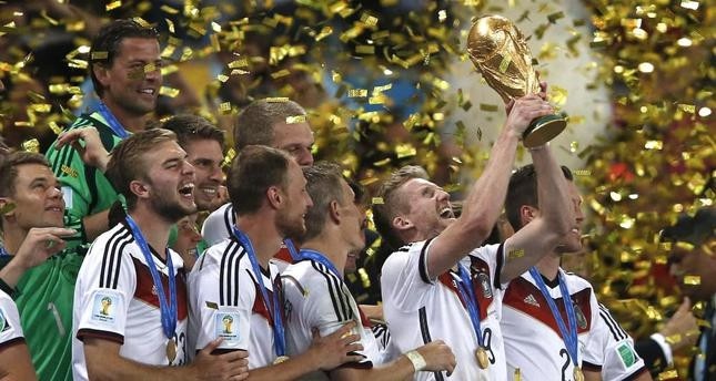Germany's forward Andre Schuerrle (C) holds the World Cup as he celebrates with teammates after his team's victory in the final between Germany and Argentina.