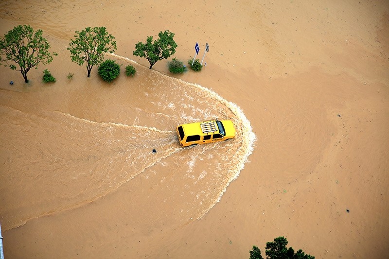 An automobile is seen passing a flooded street in Rongjiang, Guizhou Province, China, July 2, 2016. (Reuters Photo)