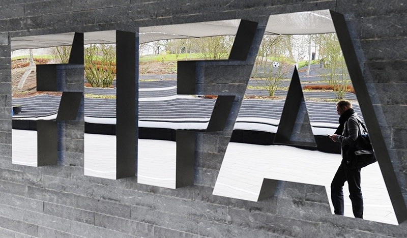 A file picture dated 19 November 2010 shows a man passing by the FIFA logo prior to a press conference following a meeting of the Executive Committee in Zurich, Switzerland. (EPA Photo)