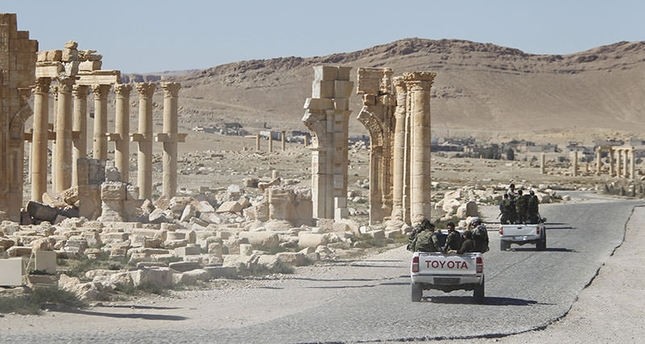Syrian army soldiers drive past the Arch of Triumph in the historic city of Palmyra, in Homs Governorate of Syria, April 1, 2016 (Reuters Photo)