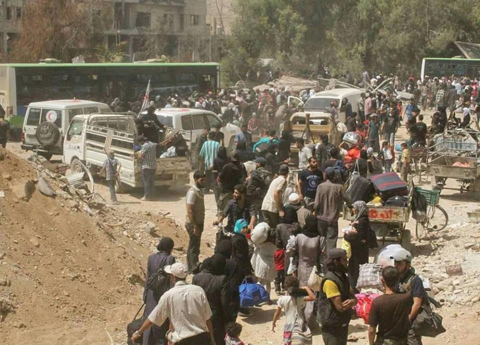 People gather before being evacuated from the besieged Damascus suburb of Daraya. (Sanaa via Reuters)