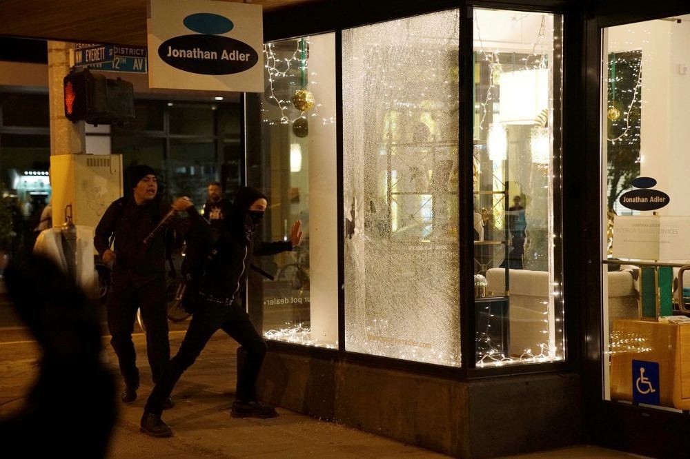 Demonstrators break a shop window during a protest against the election of Republican Donald Trump as President of the United States in Portland, Oregon, Nov. 11.