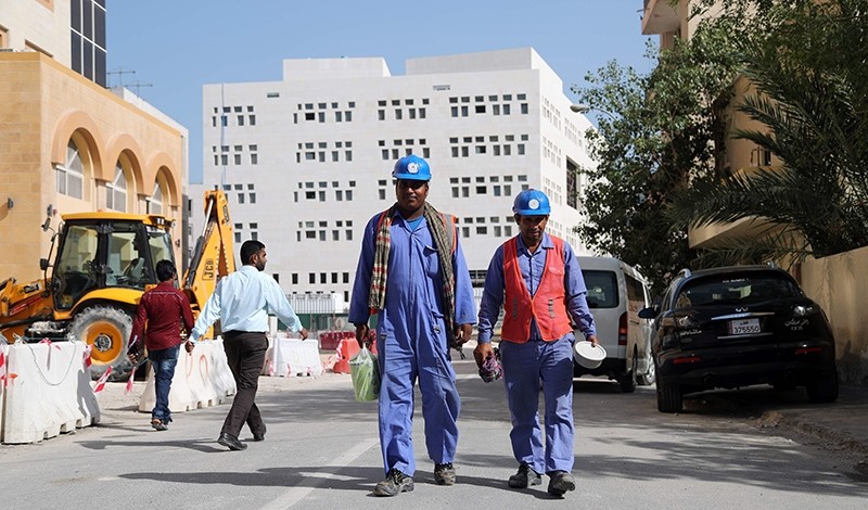 Migrant workers are seen walking next to a construction site in the Qatari capital Doha on December 6, 2016. (AFP Photo)