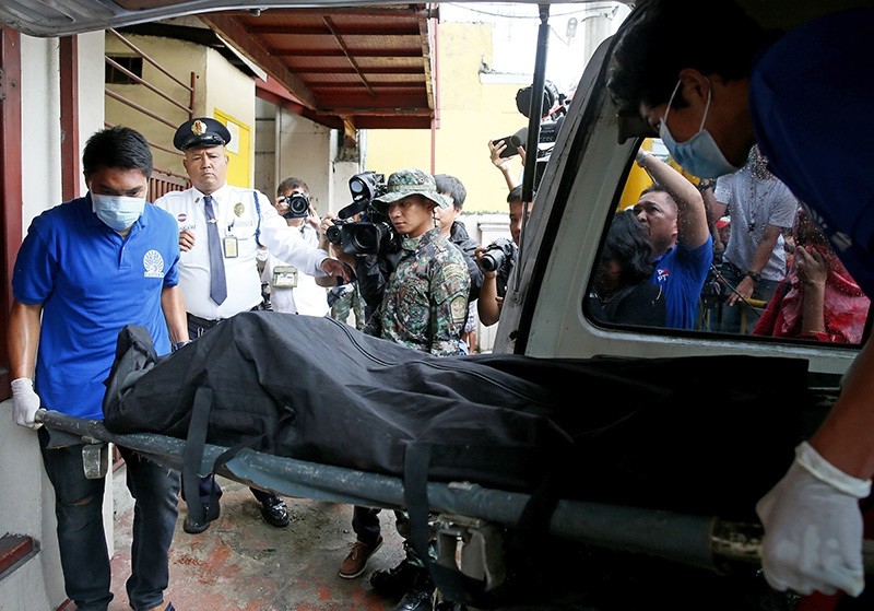 Workers carry the body of high profile inmate Tony Co after he was killed allegedly in a prison riot inside the national penitentiary, Wednesday, Sept. 28, 2016, in Muntinlupa city, Philippines. (AP Photo)