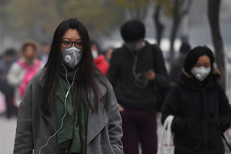 People wear masks on a polluted day in Beijing on Nov. 18, 2016. (AFP Photo)