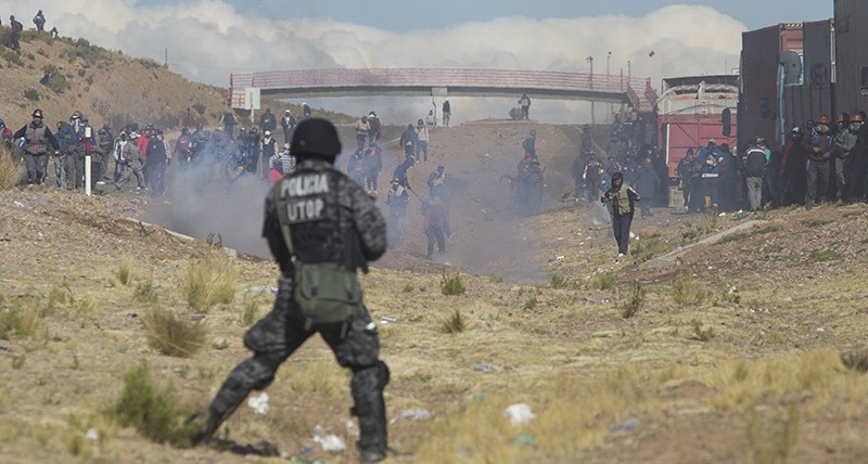 Independent miners clash with the police as they run from clouds of tear gas during protests in Panduro, Bolivia, Thursday, Aug. 25, 2016 (AP Photo)