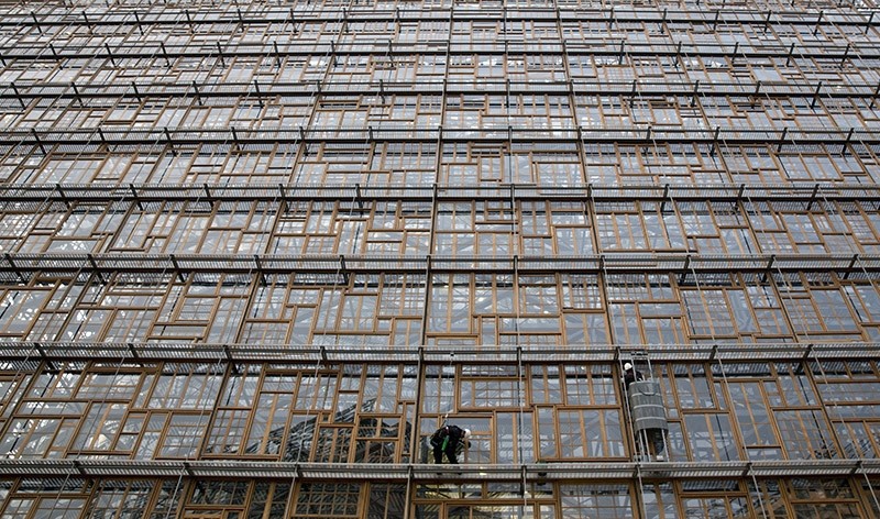 Window washers work at the new European Council building, Europa, in the European Quarter of Brussels on Thursday, Nov. 24, 2016. (AP Photo)