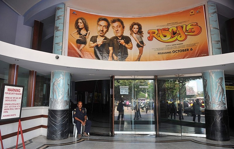 A movie theatre hall watchman sits at the Eros theatre in Mumbai, 7 October 2011. (AFP Photo)