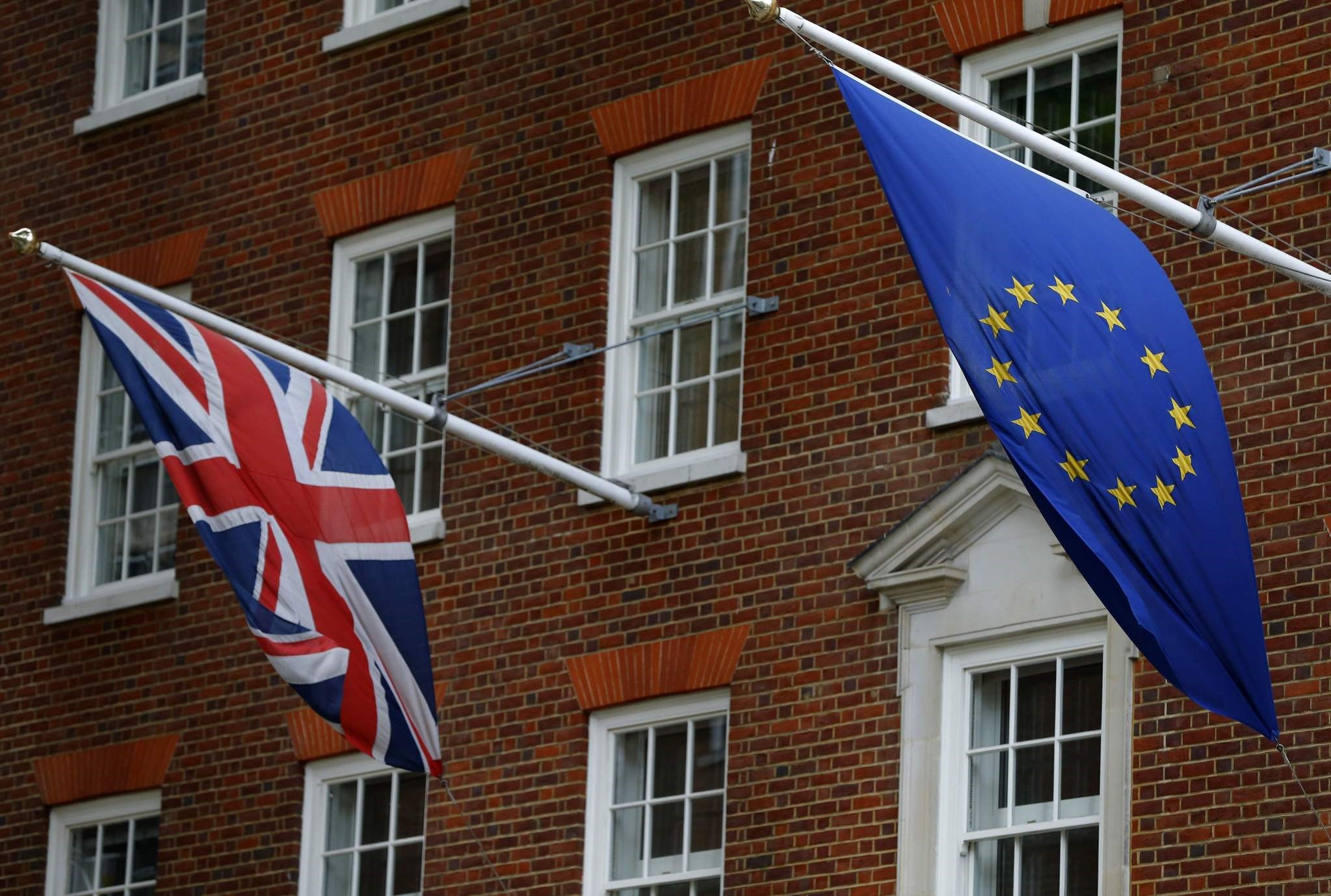 A Union flag (L), and a European Union (EU) flag fly above Europe House, the head office of the UK Representation of the European Commission, and the UK Information Office of the European Parliament. (AFP Photo)