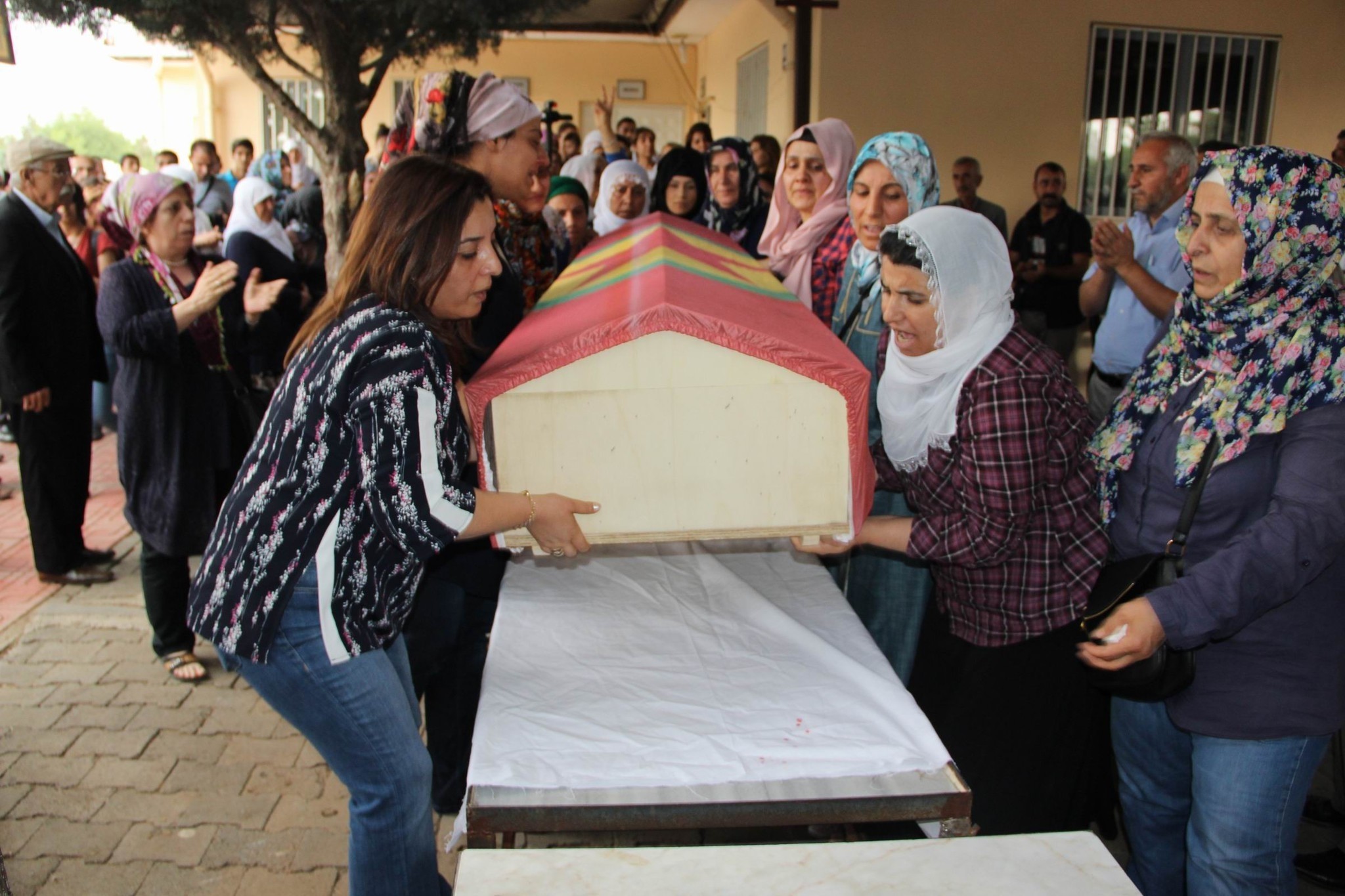 The co-mayor of Kayapu0131nar municipality in Diyarbaku0131r, Fatma Aru015fimet, is seen on the left carrying the coffin draped in a PKK flag.