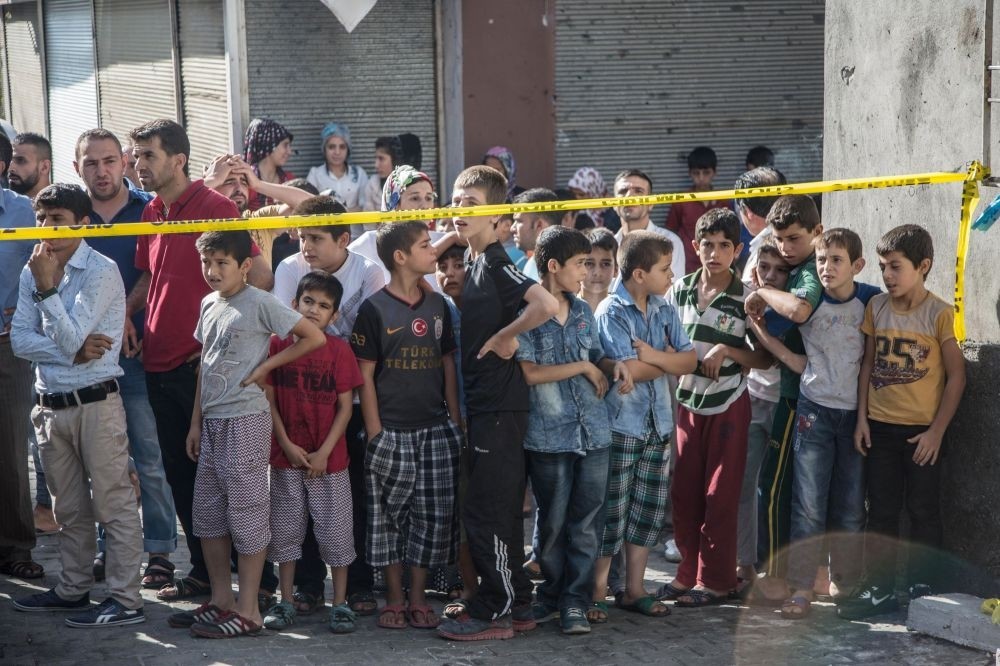People standing near the explosion scene following the latest attack on a wedding ceremony that left 51 dead and 69 wounded in southeastern Gaziantep province near Turkey's border with Syrian on Aug. 21.