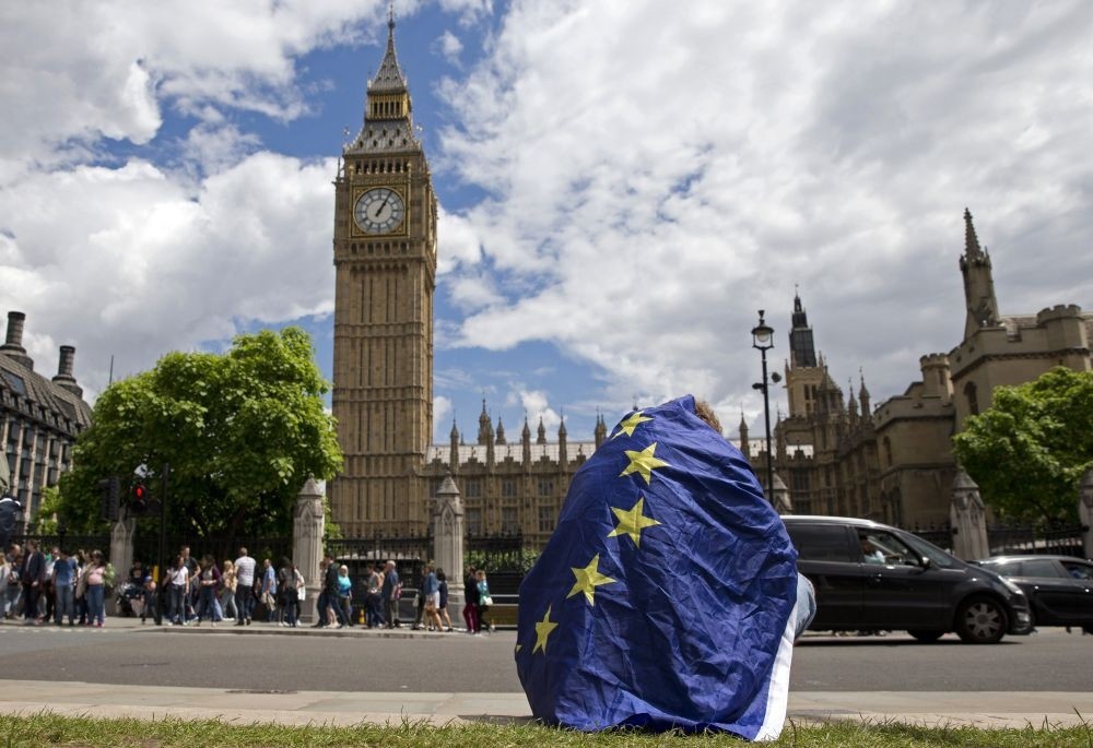 A demonstrator draped in an EU flag sits on the ground during a protest against the outcome of the U.K.'s referendum on the European Union.