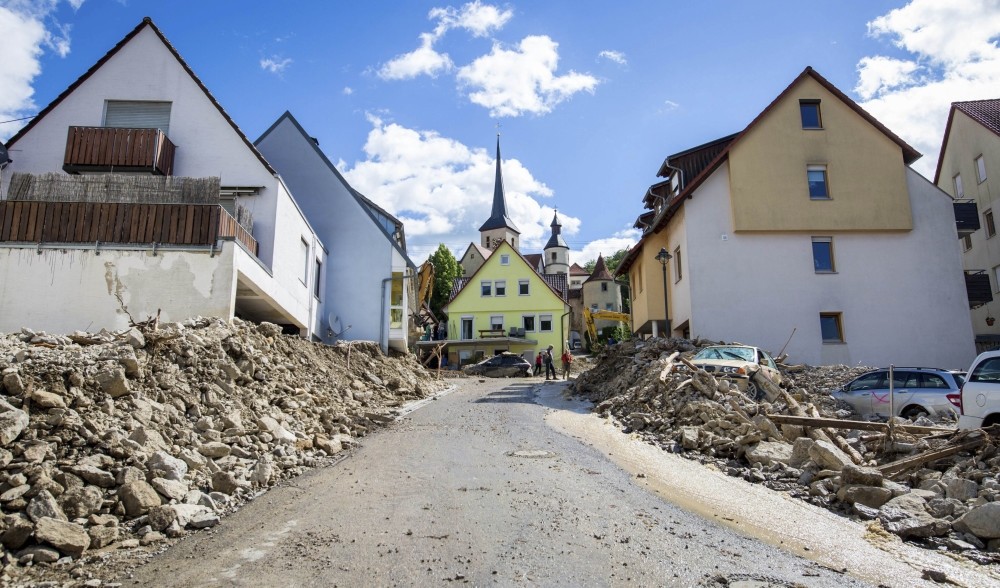 Dust coats the streets of Braunsbach and billows up as trucks bring in tar to fill the giant holes left from the devastating floods that hit the southern German village unexpectedly last month.