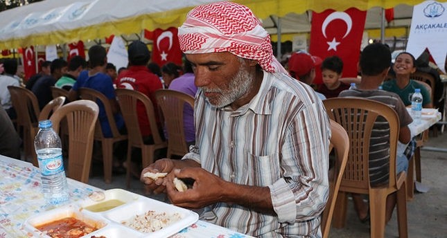 A Syrian man breaks his fast at an iftar dinner in last year's Ramadan hosted by Aku00e7akale Municipality (AA Photo)