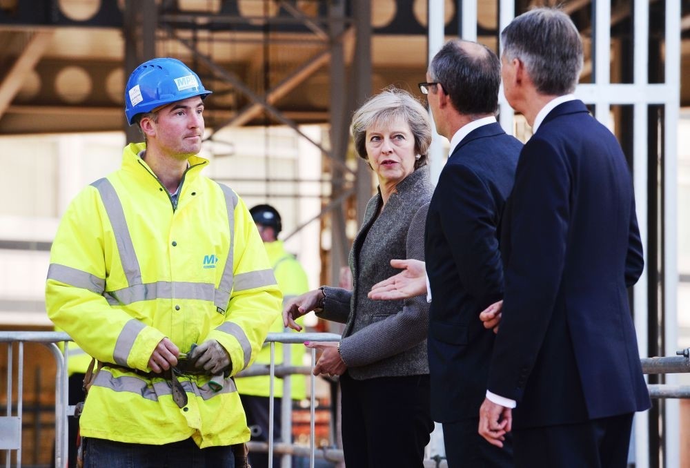 British Prime Minister Theresa May (2L) and British Chancellor of the Exchequer Philip Hammond (R) visit a construction site where new HSBC offices are being built in Birmingham Monday.
