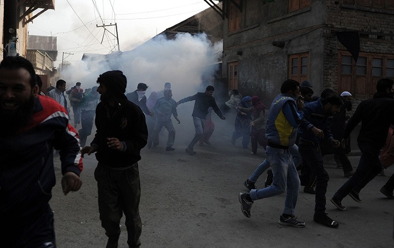 Kashmiri protesters run after Indian police fired teargas shells and pellets during the funeral procession for Qaiser Hamid, 16, killed by Indian forces in Srinagar on Nov. 5, 2016. (AFP Photo)