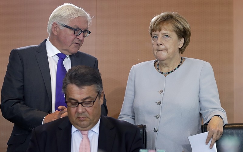  In this Aug. 31, 2016 file photo German Chancellor Angela Merkel, right, holds files as she talks to German Foreign Minister Frank-Walter Steinmeier (AP Photo)