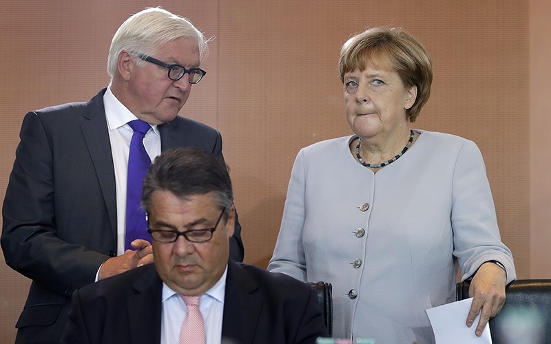  In this Aug. 31, 2016 file photo German Chancellor Angela Merkel, right, holds files as she talks to German Foreign Minister Frank-Walter Steinmeier (AP Photo)