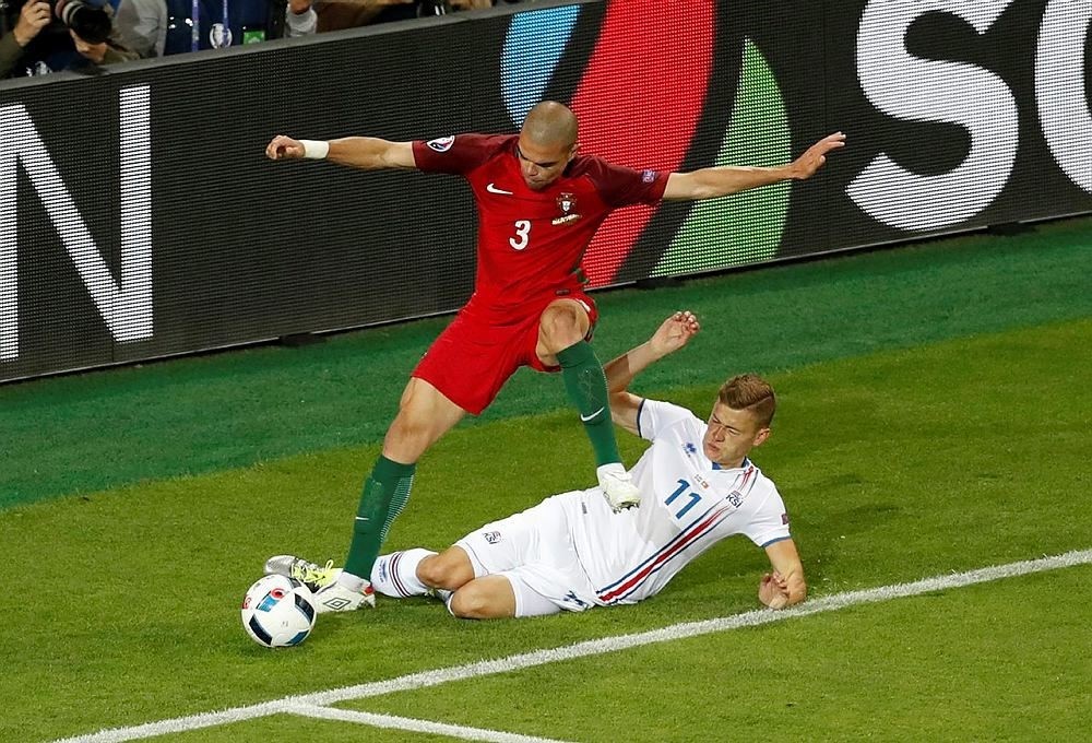 Portugal's Pepe, top, fights for the ball with Iceland's Alfred Finnbogason during the Euro 2016 Group F soccer match between Portugal and Iceland at the Geoffroy Guichard stadium in Saint-Etienne, France, Tuesday, June 14, 2016. (AP Photo)