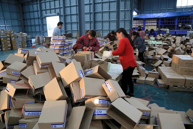 Workers wrapping packages at a logistics center in Lianyungang, east China's Jiangsu province. China's courier services are planning ahead to cope with Singles' Day, yearly shopping boom day. Nov. 8, 2016. (AFP Photo)