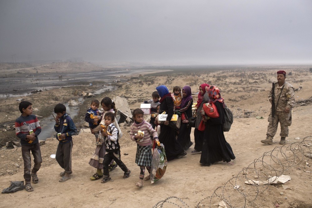Internally displaced persons clear a checkpoint in Qayara, some 50 kilometers south of Mosul, Iraq, Oct. 26, 2016. 