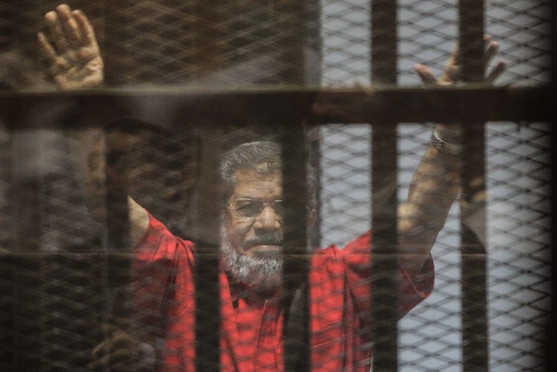 Mohamed Morsi gestures during a trial session on charges of espionage in Cairo, Egypt, 18 June 2016. (EPA)